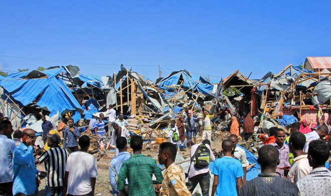 Bystanders surveyed damage from a car bomb in Mogadishu, Somalia, on Saturday. The blast killed at least 11 people and wounded 16 others.