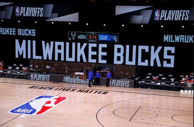 Referees stand on an empty court before the start of a scheduled playoff game between the Milwaukee Bucks and the Orlando Magic. (Kevin C. Cox/Getty Images)