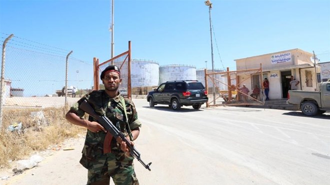 A member of the Petroleum Facilities Guard is seen at the entrance of Azzawiyah Oil Refinery, in Zawiyah west of Tripoli, Libya [Ismail Zitouy/Reuters]