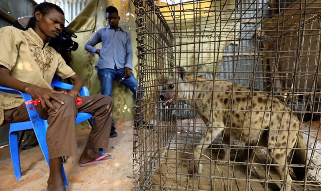 Mohamed Sheikh Yakub, a patient suffering with mental illeness, sits inside the treament room where a hyena believed to exorcise evil spirits that cause mental illness is secured in a cage, in Hodan dirtict of Mogadishu, Somalia - Februray 15, 2020 (Reuters/Feisal Omar)