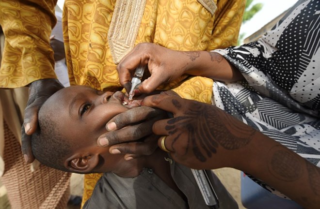 A health worker tries to immunize a child during a vaccination campaign against polio./PIUS UTOMI EKPEI/Getty Images)