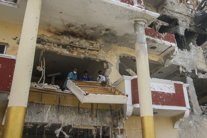 People remove damaged furniture from the destroyed Hayat Hotel, days after a deadly siege by al-Shabab extremists, in Mogadishu, Somalia Wednesday, Aug. 24, 2022. The siege was the longest such attack in the country's history taking more than 30 hours for security forces to subdue the extremists, with more than 20 people killed. (AP Photo/Farah Abdi Warsameh)