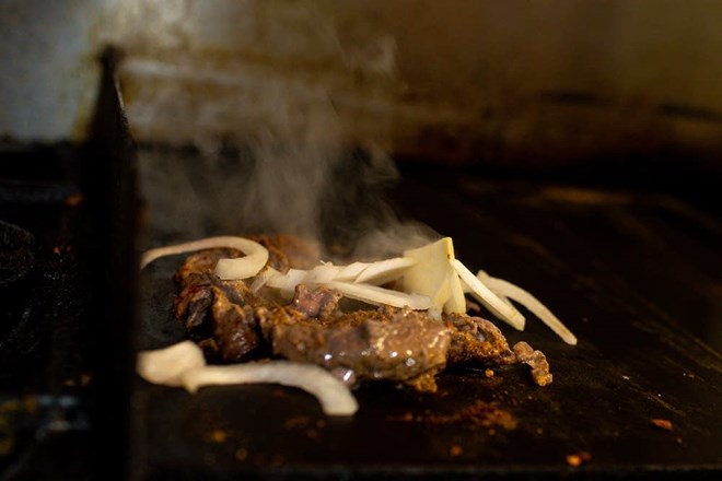 Karima Omer, owner of Sabrina's Cafe & Deli in St. Paul, cooks beef with spices and onions for a chapati and beef wrap.Nicole Neri for MPR News