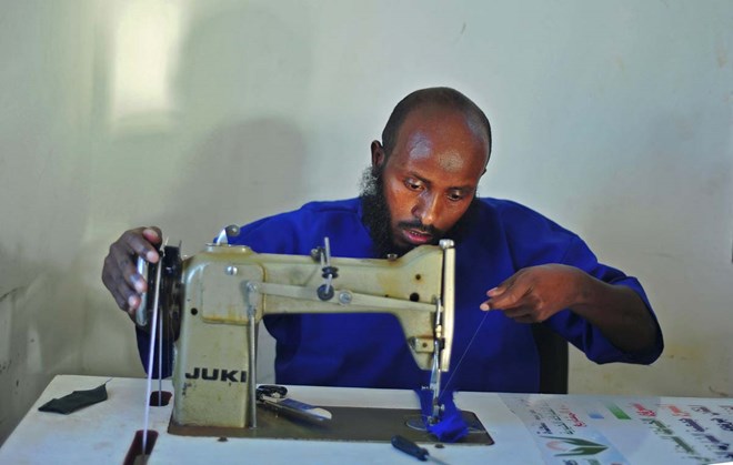 A prisoner sews at a prison in Garowe, Puntland state, in northeastern Somalia, on December 14, 2016. The prison facilitates the rehabilitation of convicted Somali pirates and suspected Al-Shabaab jihadists. (MOHAMED ABDIWAHAB/AFP/Getty Images)