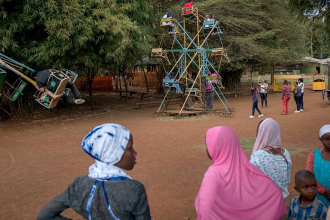 Visitors ride a ferris wheel at the Mamba crocodile farm. Credit Sam Wolson for The New York Times