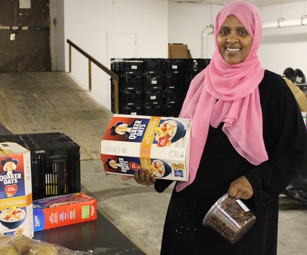 Fartun Weli is distributing dates and oatmeal at the nonprofit Isuroon’s new food shelf on Nicollet. Photo by Michelle Bruch