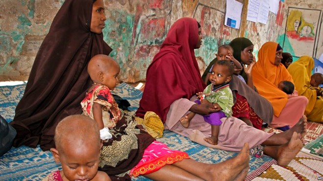 FILE - In this photo taken March 25, 2017, Somali women and their malnourished children attend a health center in Baidoa, Somalia.