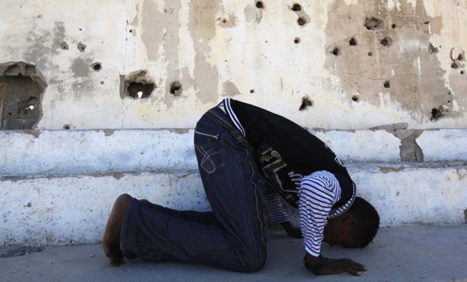 FILE - Somali athlete Abdullah Bare Kuulow prays after a training session in preparation for the 2012 London Olympic Games inside Mogadishu Stadium, March 16, 2012. AFRICOM troops have relocated from the complex, returning its main focus to athletics.