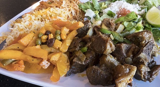 Somali dishes including goat and potatoes plus salad, rice, and pasta