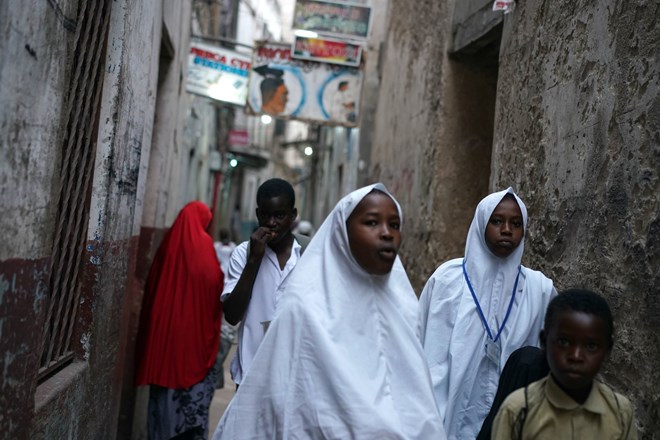Schoolchildren in one of Lamu’s narrow streets. The town, a Unesco world heritage site, was established in the 14th century. Credit Joao Silva/The New York Times