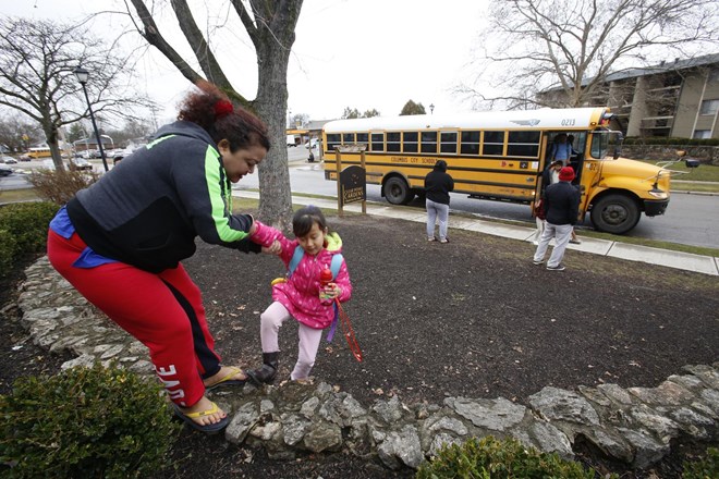 Harka Gurung, a 36-year-old refugee from Bhutan, lifts her 8-year-old daughter, Eden Gurung, as she arrives from school in Columbus, Ohio, on Wednesday, Feb. 21, 2018. Harka, her husband and daughter were the first of their family to arrive from a refugee camp in Nepal. Her parents and a sister joined them in February after a four-year separation. Columbus is home to about 20,000 Bhutanese immigrants, representing the largest Bhutanese community in the United States. (AP Photo/martha Irvine)