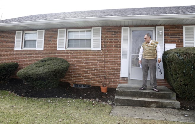 Rifat Moustafa, a Syrian immigrant, takes a smoke break outside his Columbus, Ohio, home on Thursday, Feb. 22, 2018. His 16-year-old son, Hasib Moustafa Rifat, has been separated from his family for more than 18 months as he awaits a U.S. visa. Moustafa, an international lawyer who says he was tortured for protesting human rights violations, was granted asylum and his wife and four other children followed in 2016, before President Trump was elected. They were hoping Hasib could come shortly after, but resettlement officials say the Trump administration’s travel ban on refugees from mostly Muslim countries has very likely caused further delays. (AP Photo/martha Irvine)