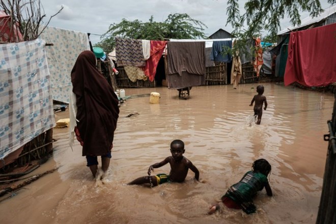 Children play in floodwaters after a downpour . AFP/File/Yasuyoshi CHIBA