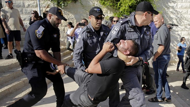 Israeli police officers detain a demonstrator during a protest outside the U.S. embassy in Jerusalem, during the embassy's official inauguration ceremony, Monday, May 14, 2018.