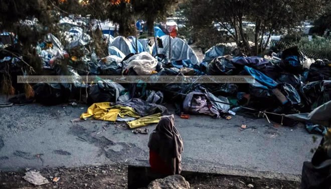 A refugee sits in an overcrowded camp on the Greek island of Samos, March 2019. (AP Photo / Angelos Tzortzinis)